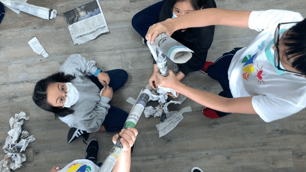 A group of Singapore international students holding a newspaper