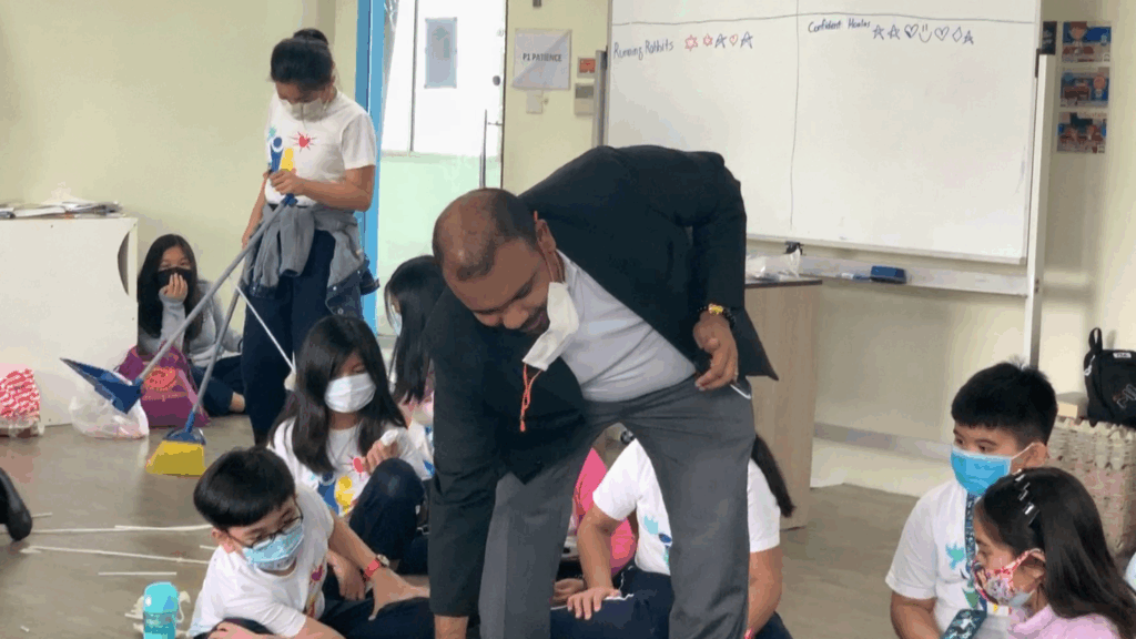 International school students in Singapore, along with their teacher, actively participating in a class activity.